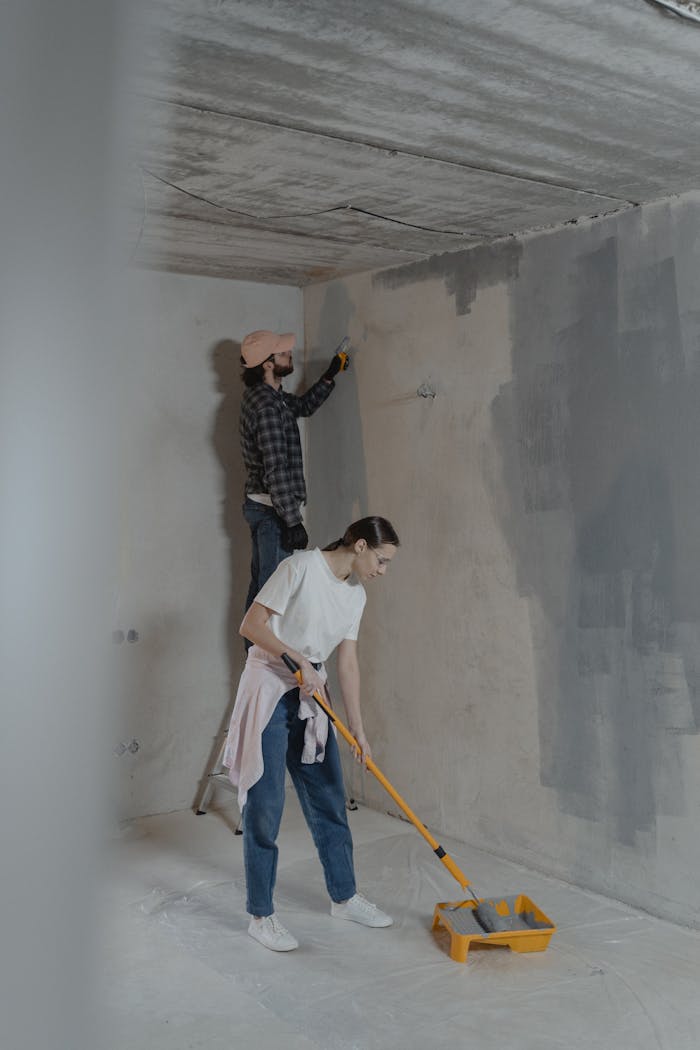 gallery-02 A couple engaged in painting interior walls as part of a home renovation project.